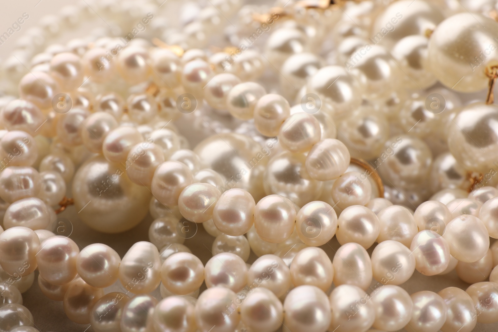 Photo of Elegant pearl necklaces as background, closeup view