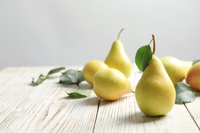 Photo of Ripe pears on wooden table. Space for text