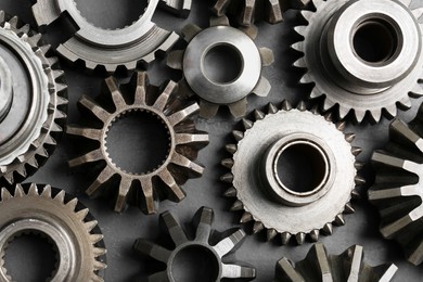 Photo of Many different stainless steel gears on grey background, flat lay
