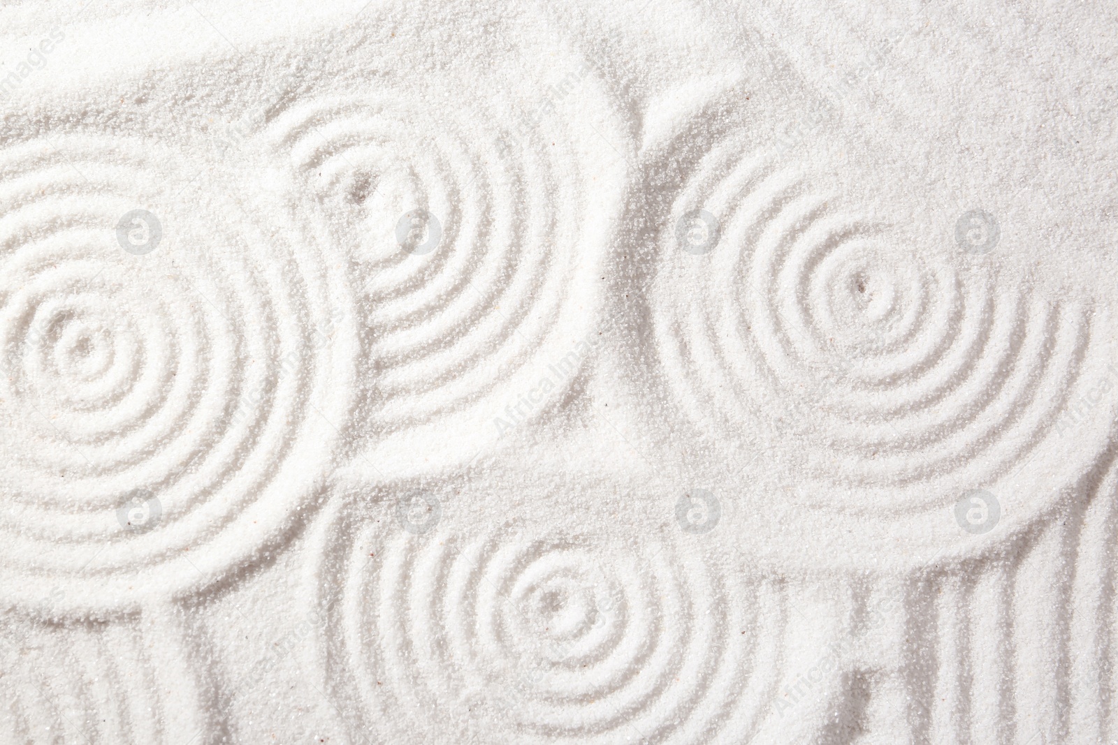 Photo of Zen rock garden. Circle patterns on white sand, top view