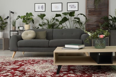 Photo of Cozy room interior with stylish furniture, houseplants and decor elements