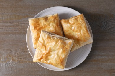 Delicious fresh puff pastries on wooden table, top view