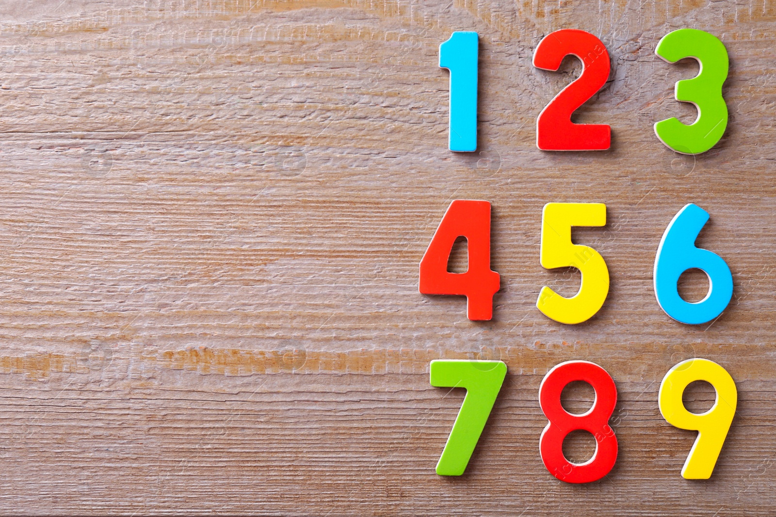 Photo of Colorful numbers on wooden table, flat lay. Space for text