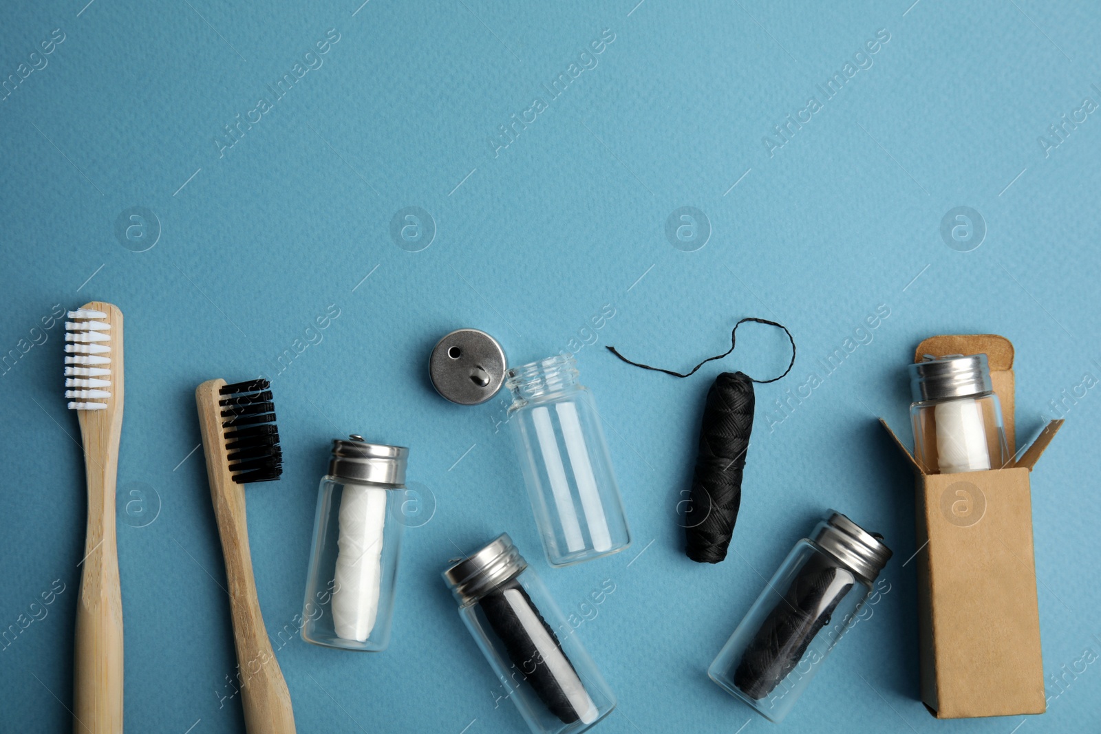 Photo of Flat lay composition with natural dental floss on light blue background. Space for text