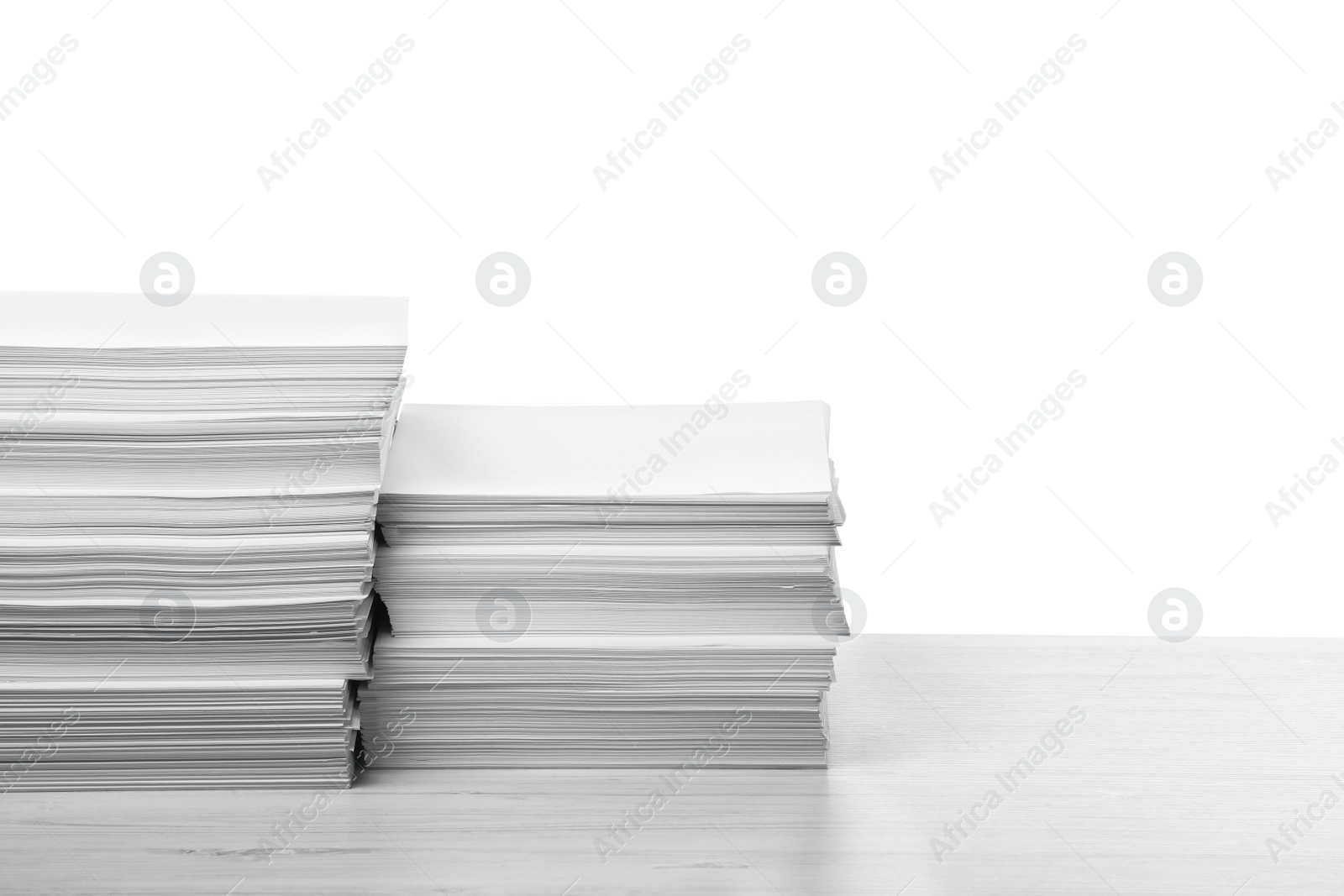 Photo of Stacks of paper sheets on light wooden table against white background. Space for text
