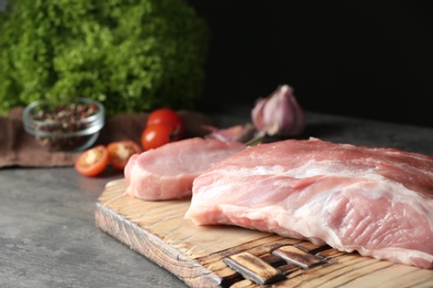 Photo of Fresh raw meat on table against dark background, closeup. Space for text