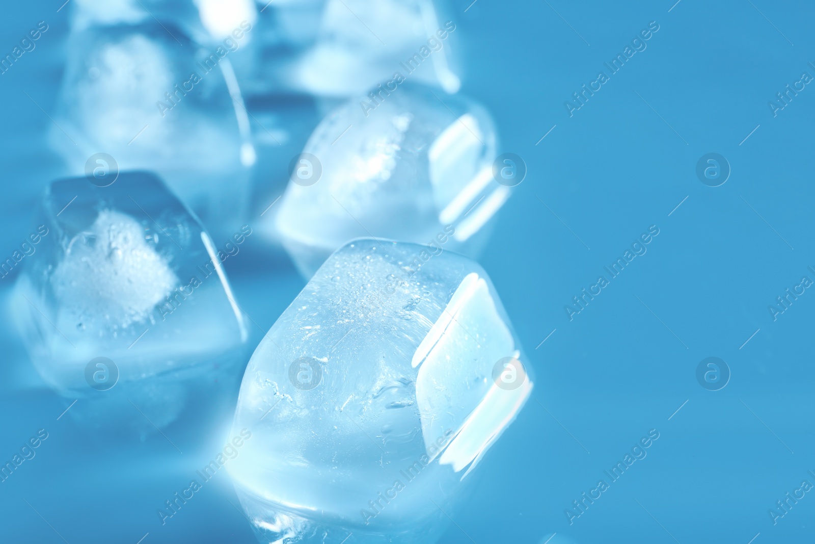 Photo of Ice cubes on color background. Space for text