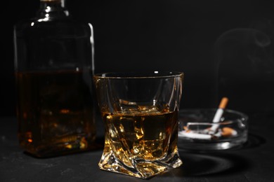 Alcohol addiction. Whiskey in glass on dark textured table, closeup