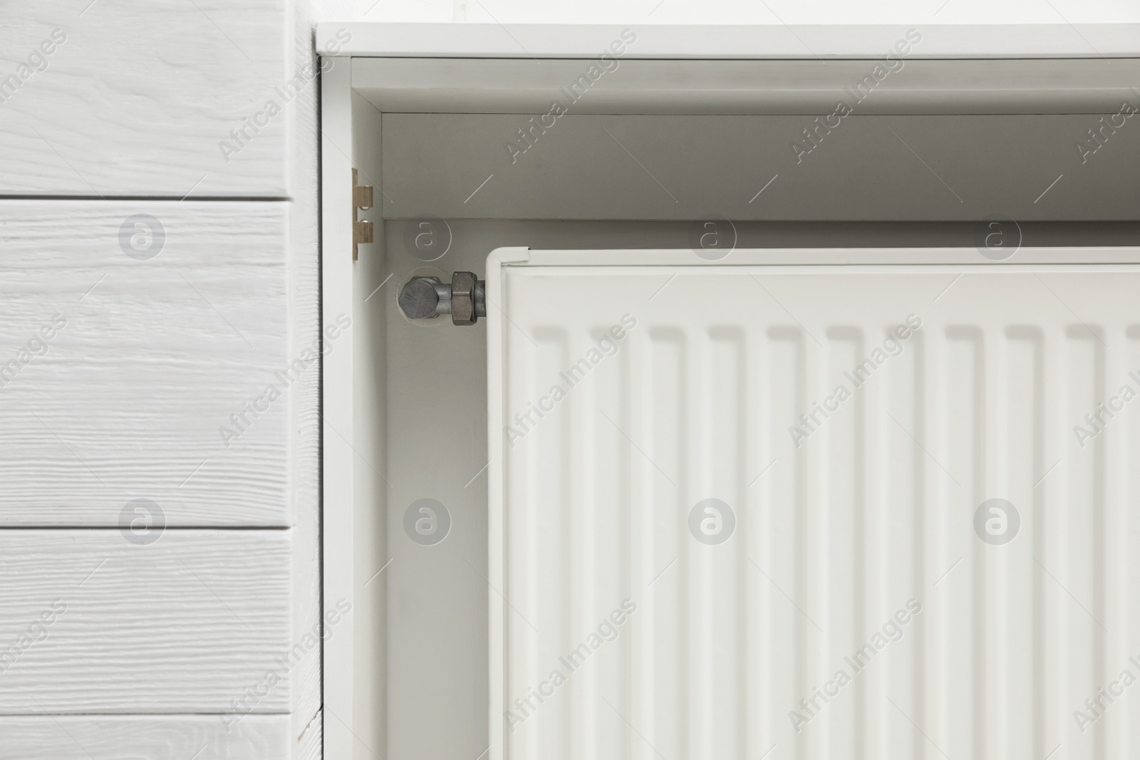 Photo of Closeup view of modern radiator. Central heating system