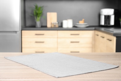 Photo of Napkin on wooden table in kitchen. Mockup for design