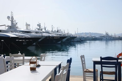 Photo of Beautiful view of outdoor cafe near pier with different boats