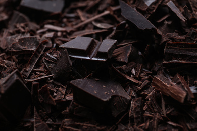 Photo of Tasty crushed dark chocolate as background, closeup