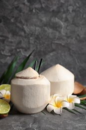 Photo of Composition with fresh coconut drink in nut on grey table