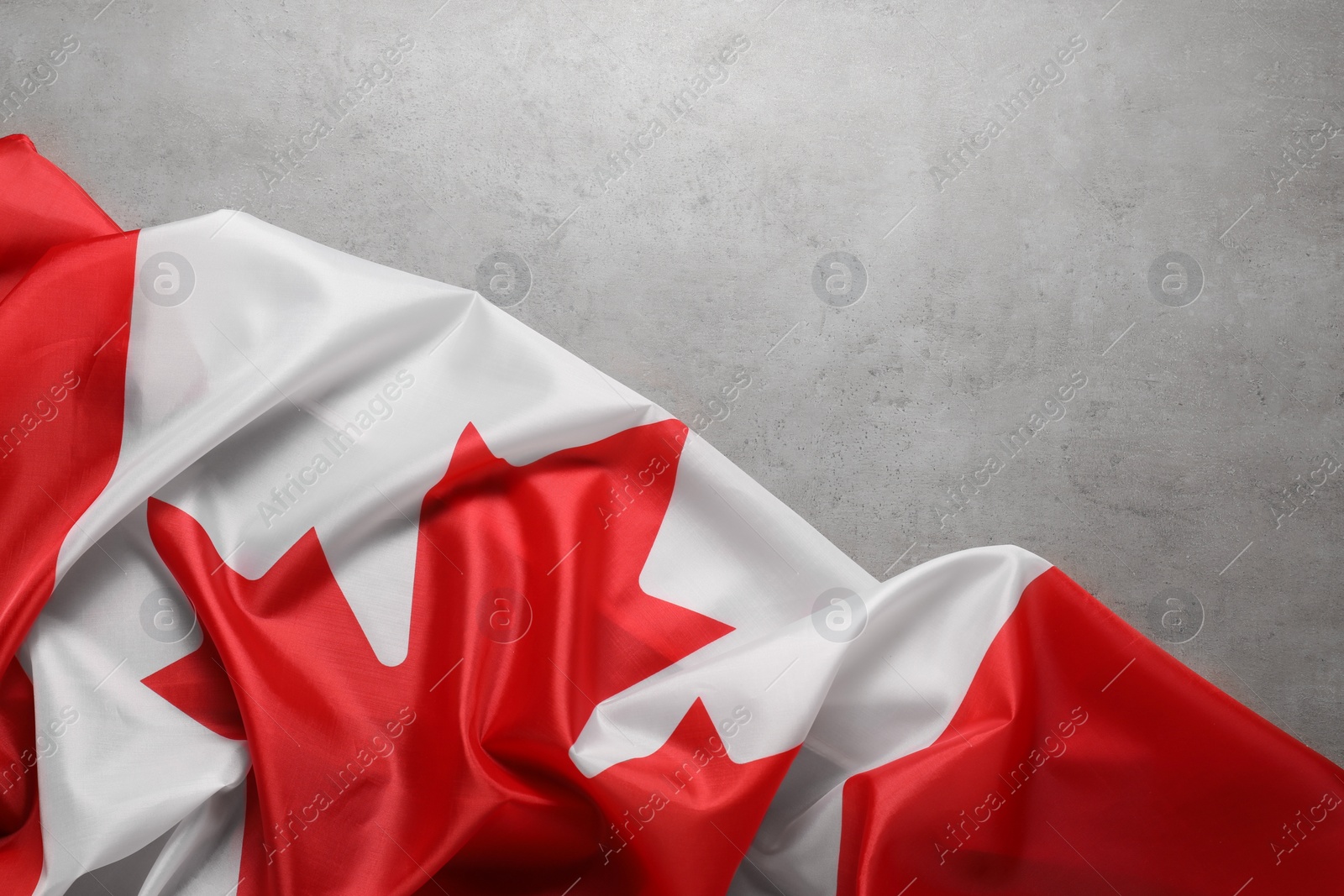 Photo of Flag of Canada on gray background, top view. Space for text