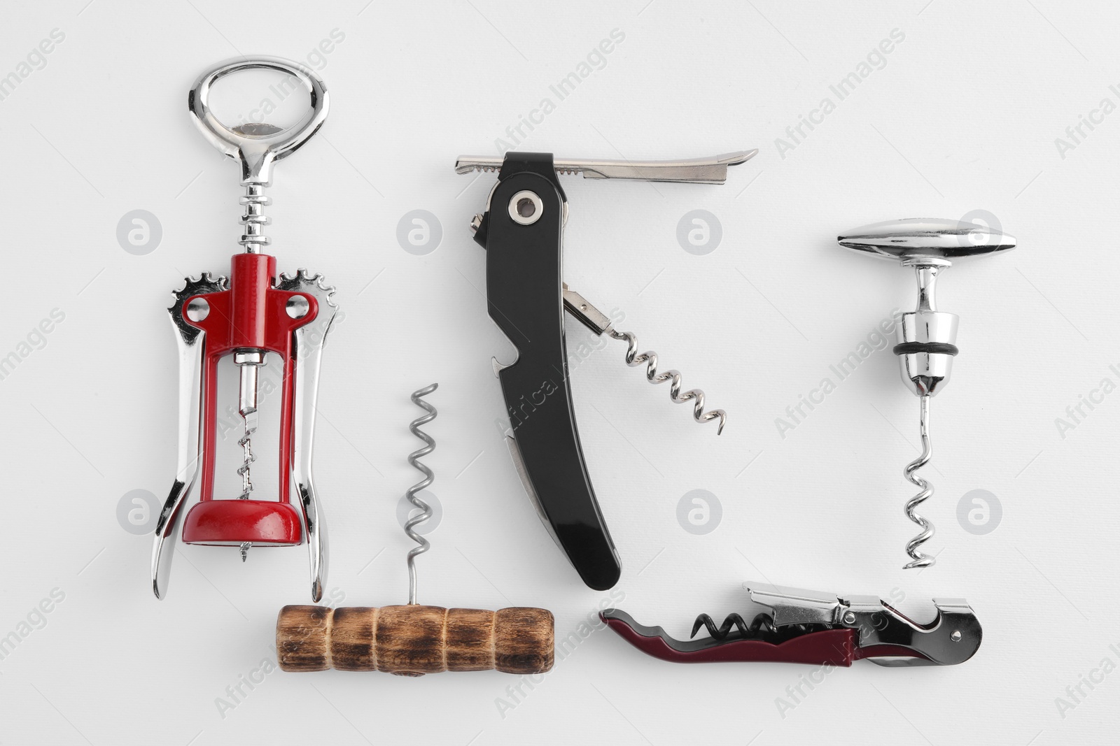 Photo of Different corkscrews on white background, flat lay