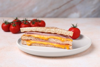 Photo of Delicious grilled sandwich with ham, cheese and tomatoes on light table