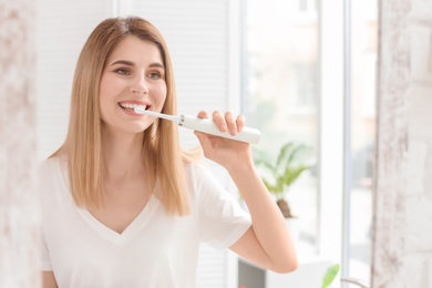 Young woman brushing her teeth in bathroom