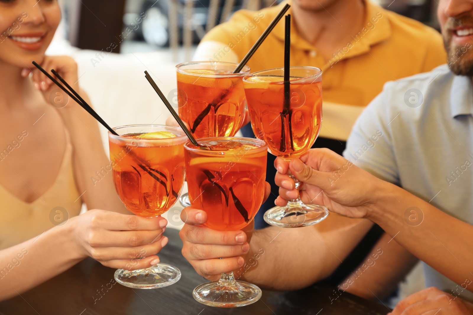 Photo of Friends with Aperol spritz cocktails resting together at restaurant, closeup