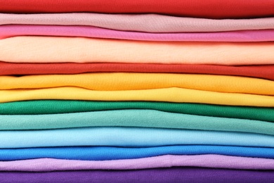 Photo of Stack of colorful t-shirts, close up view