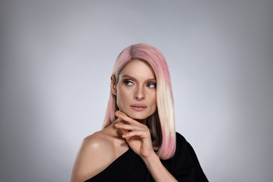 Image of Hair styling. Gorgeous woman with colorful hair on grey background