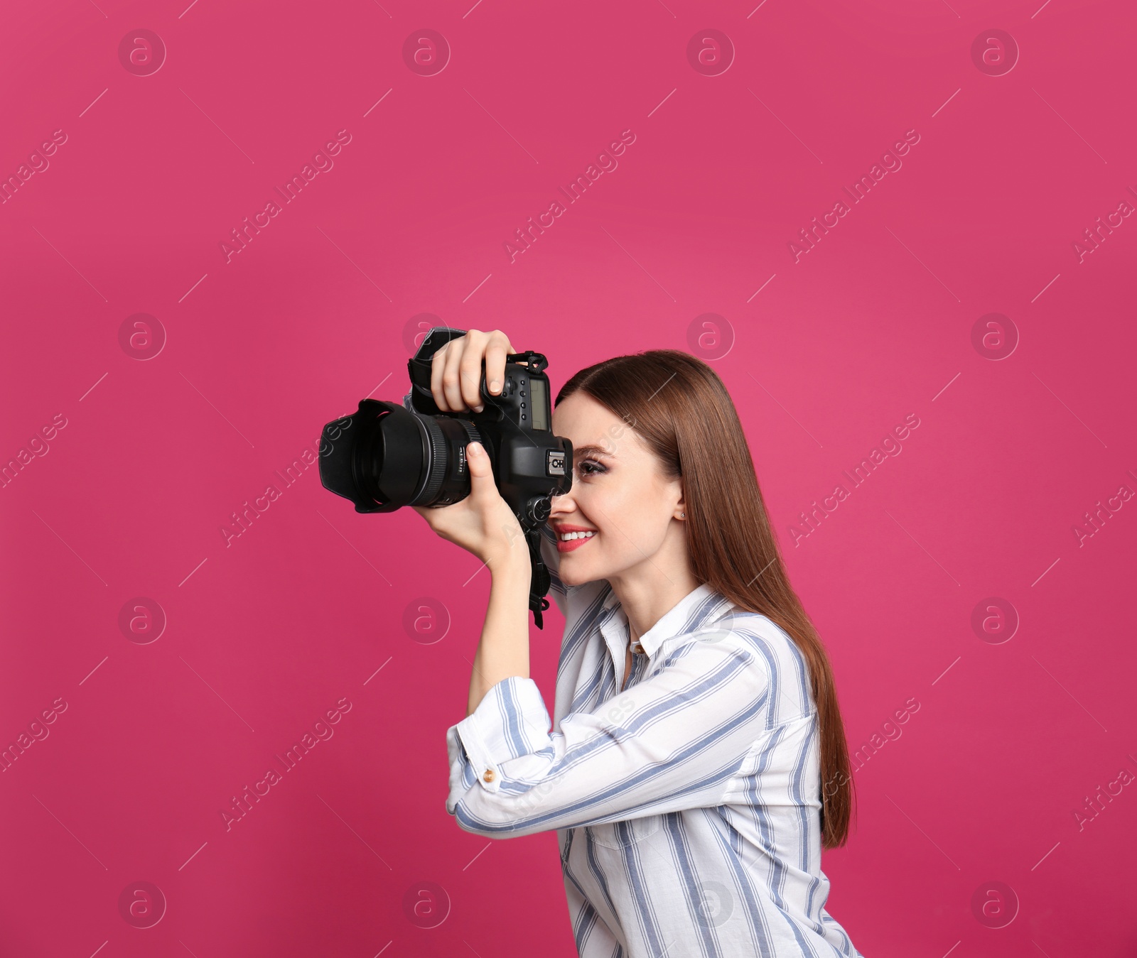 Photo of Professional photographer taking picture on pink background