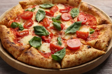 Photo of Delicious Margherita pizza on wooden table, closeup