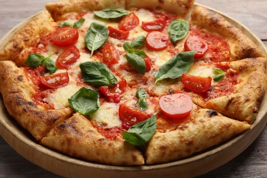 Delicious Margherita pizza on wooden table, closeup