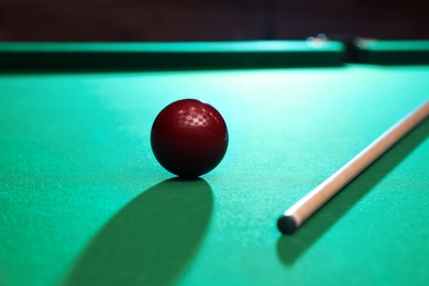 Photo of Red billiard ball and cue on table