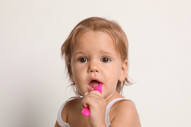Photo of Cute little girl with toothbrush on white background