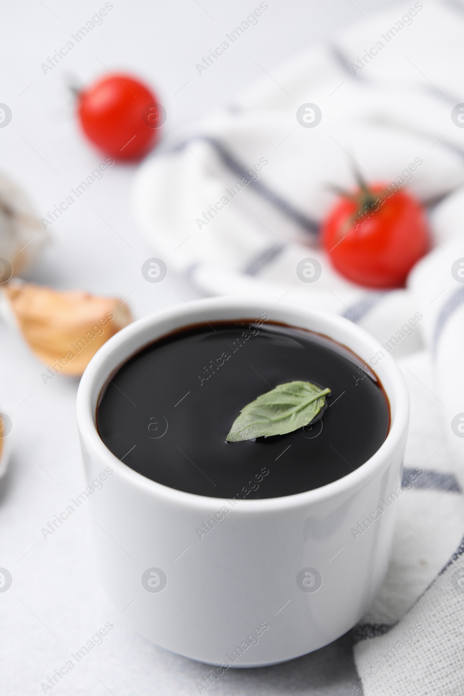 Photo of Organic balsamic vinegar and cooking ingredients on white table, closeup