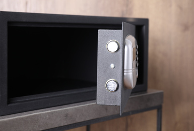 Black steel safe with electronic lock on grey table, closeup