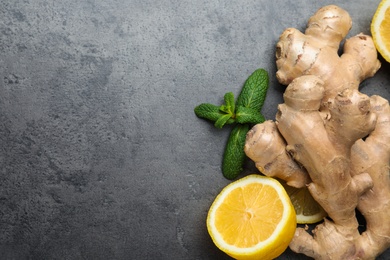 Photo of Fresh lemon, ginger and mint on grey table, flat lay. Space for text