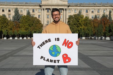 Photo of Man with poster protesting against climate change on city street