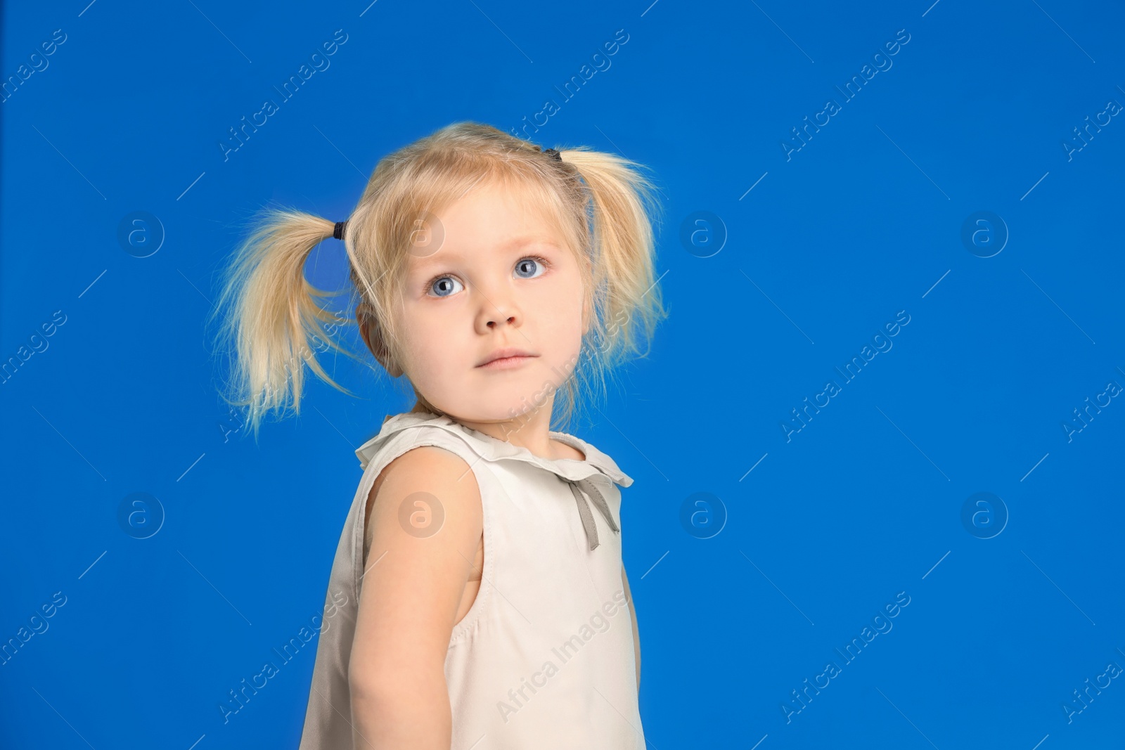 Photo of Cute little girl posing on light blue background