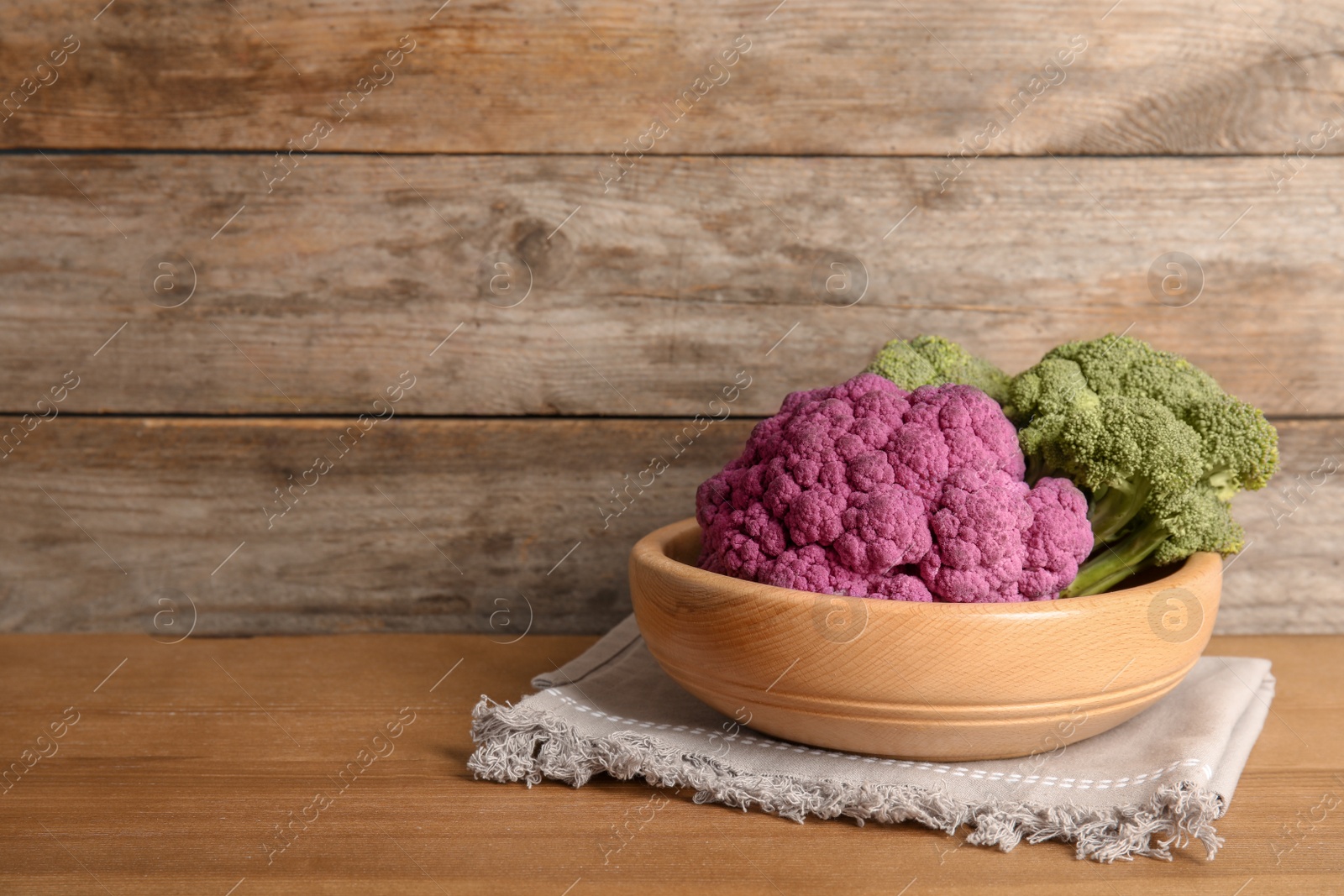 Photo of Plate with different cabbages on wooden table. Healthy food