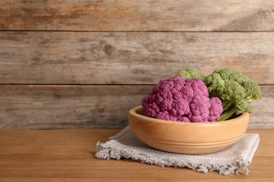 Plate with different cabbages on wooden table. Healthy food