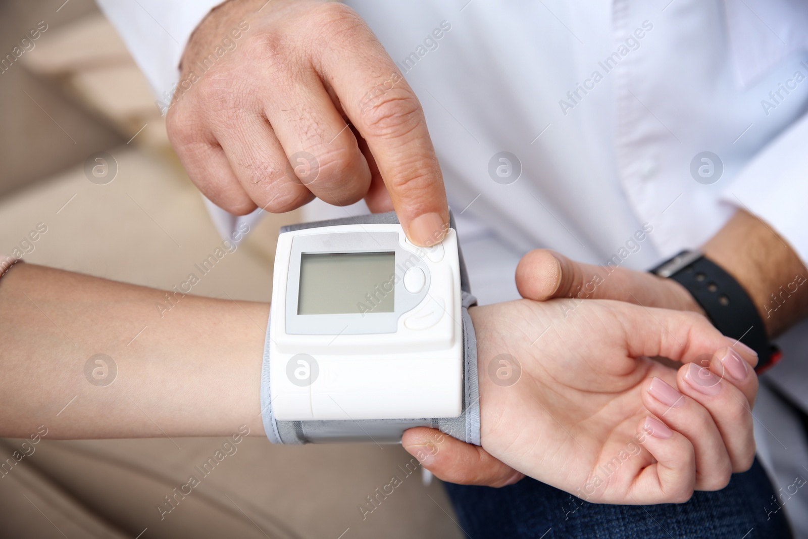Photo of Doctor checking young woman's pulse with medical device indoors, closeup