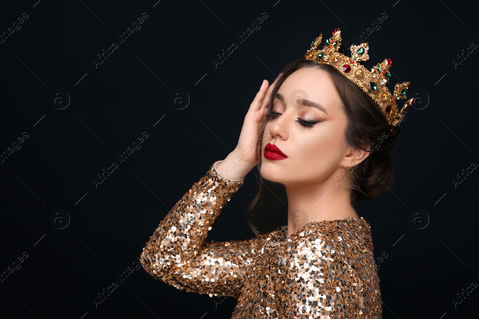 Photo of Beautiful young woman wearing luxurious crown on black background, space for text