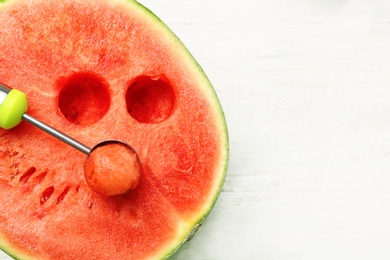 Photo of Scoop with delicious juicy watermelon on white wooden table, top view. Space for text