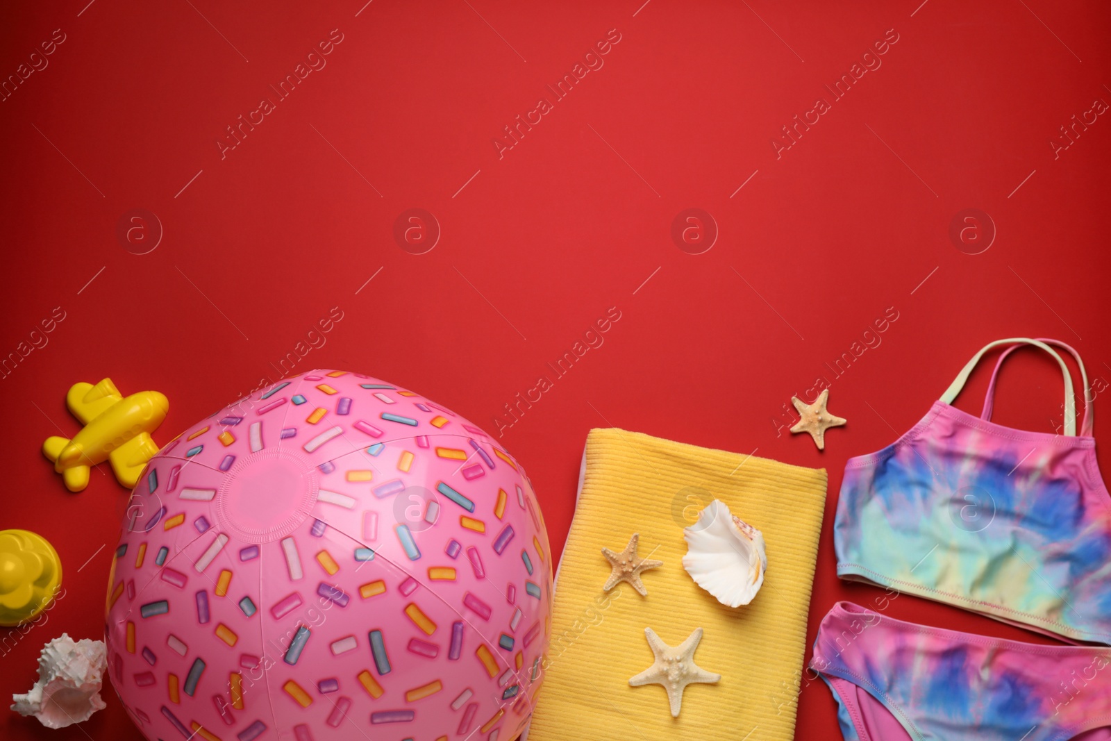 Photo of Flat lay composition with ball and beach objects on red background, space for text