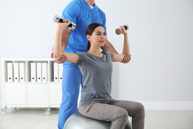 Photo of Doctor working with patient in hospital. Rehabilitation exercises