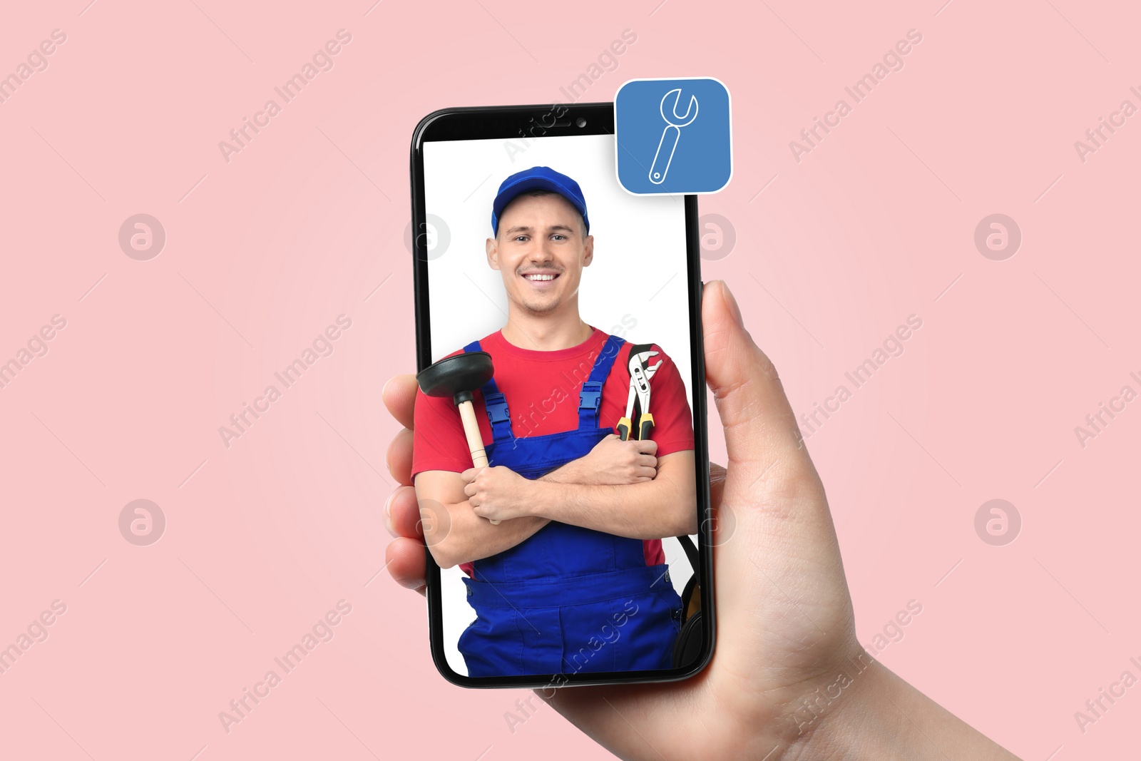 Image of Find plumber. Woman using mobile phone on pink background, closeup. Specialist looking out of gadget