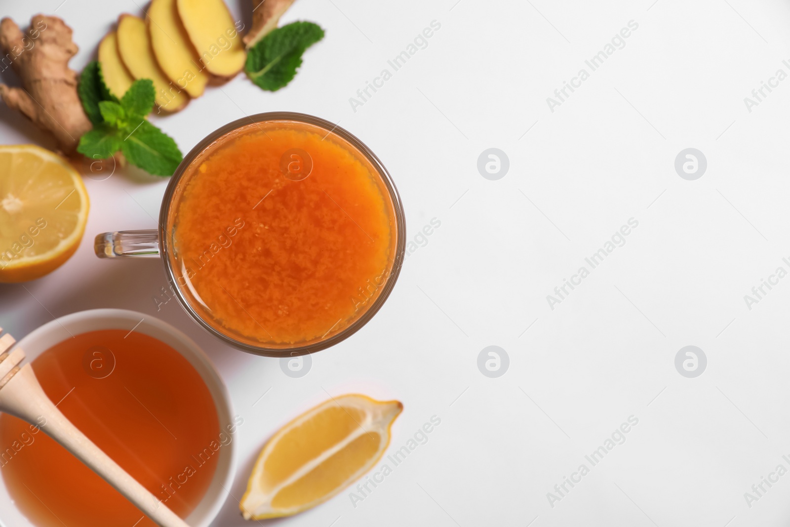 Photo of Delicious ginger tea and ingredients on white background, flat lay. Space for text