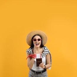 Photo of Happy female tourist with ticket and passport on yellow background