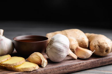 Photo of Fresh garlic and other natural cold remedies on table, closeup