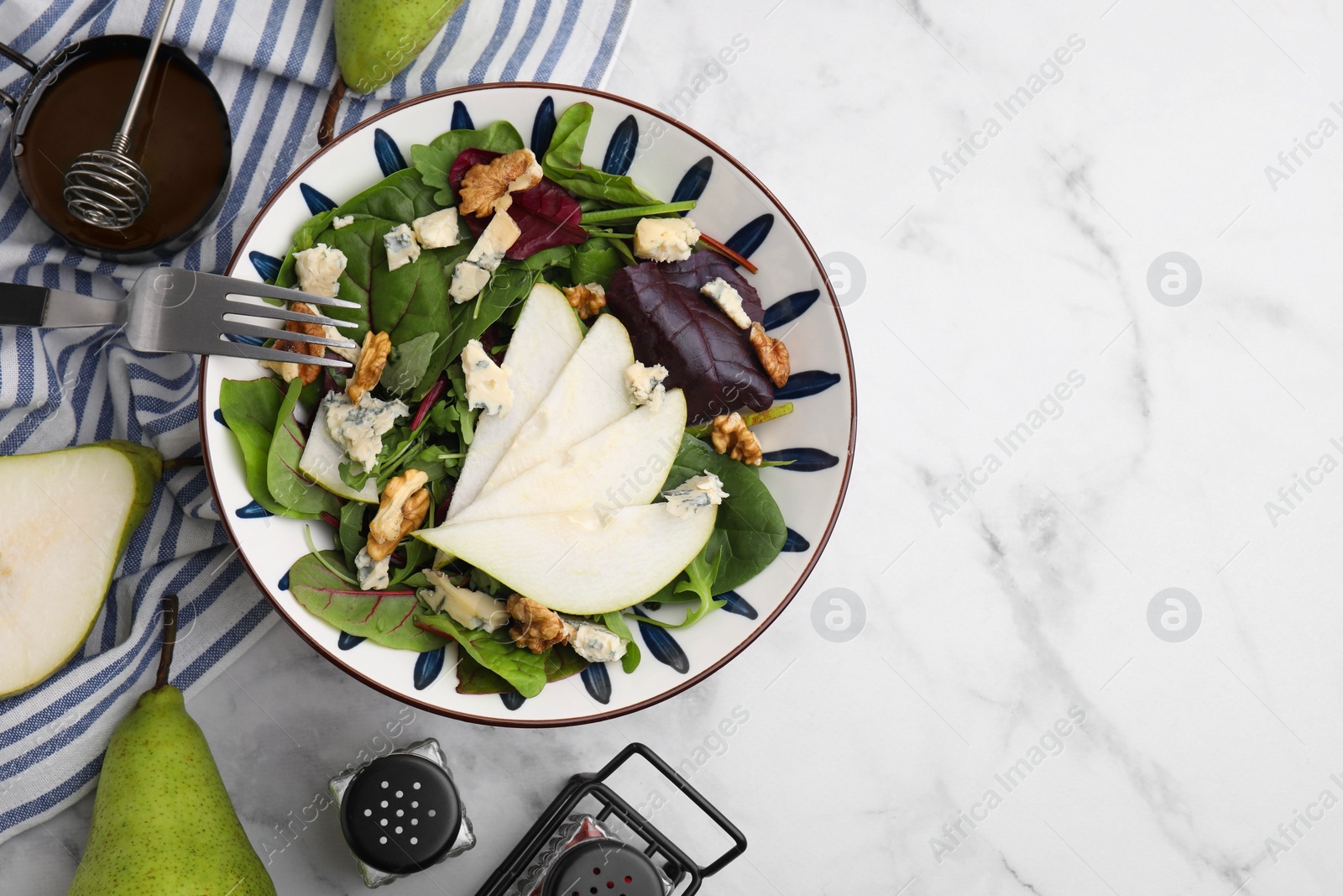 Photo of Delicious pear salad in bowl served on white marble table, flat lay. Space for text