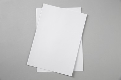 Photo of Blank brochures on grey background, top view. Mockup for design