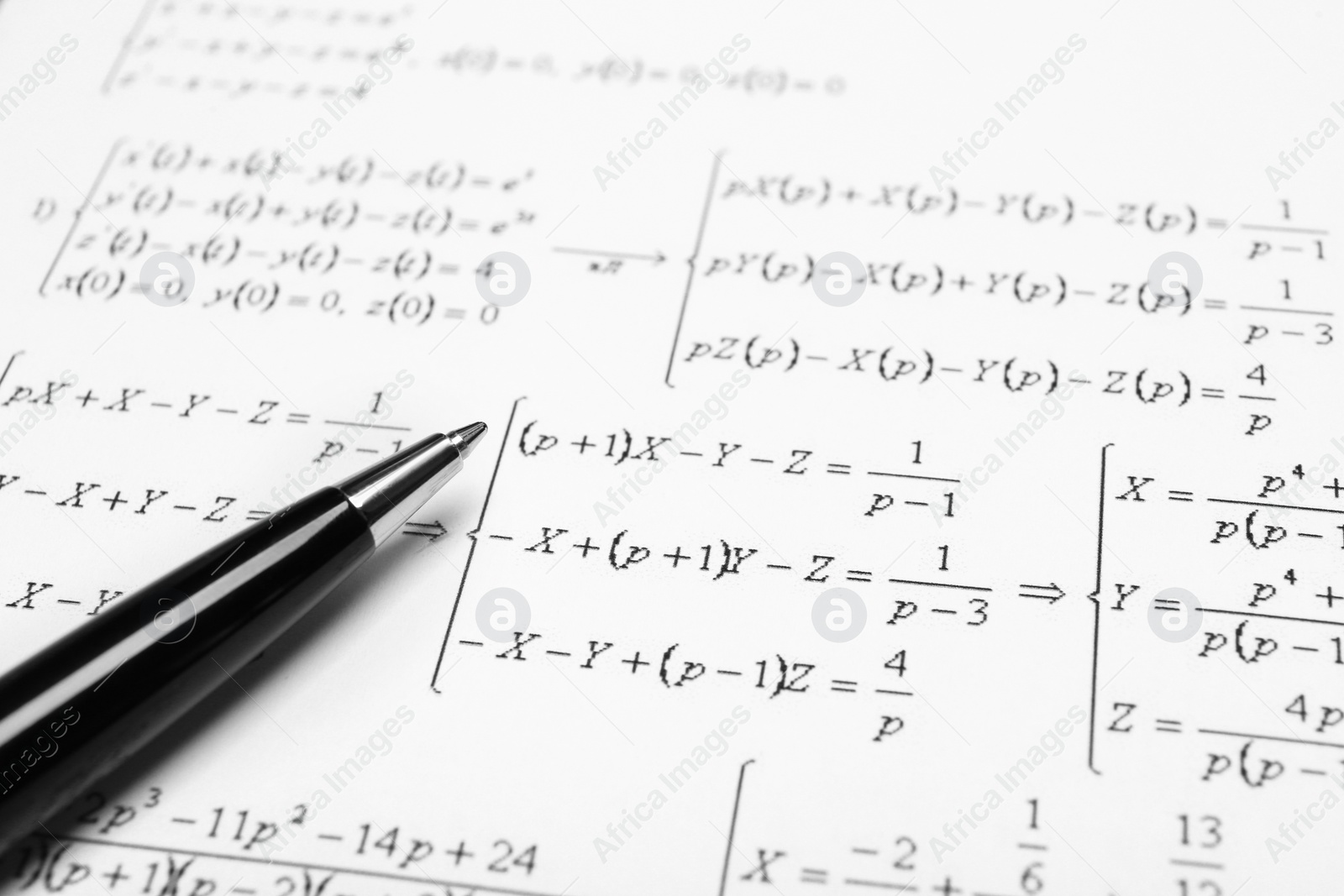 Photo of Sheet of paper with mathematical formulas and pen, closeup