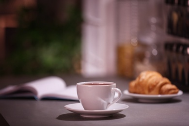 Photo of Cup of hot coffee on blurred background