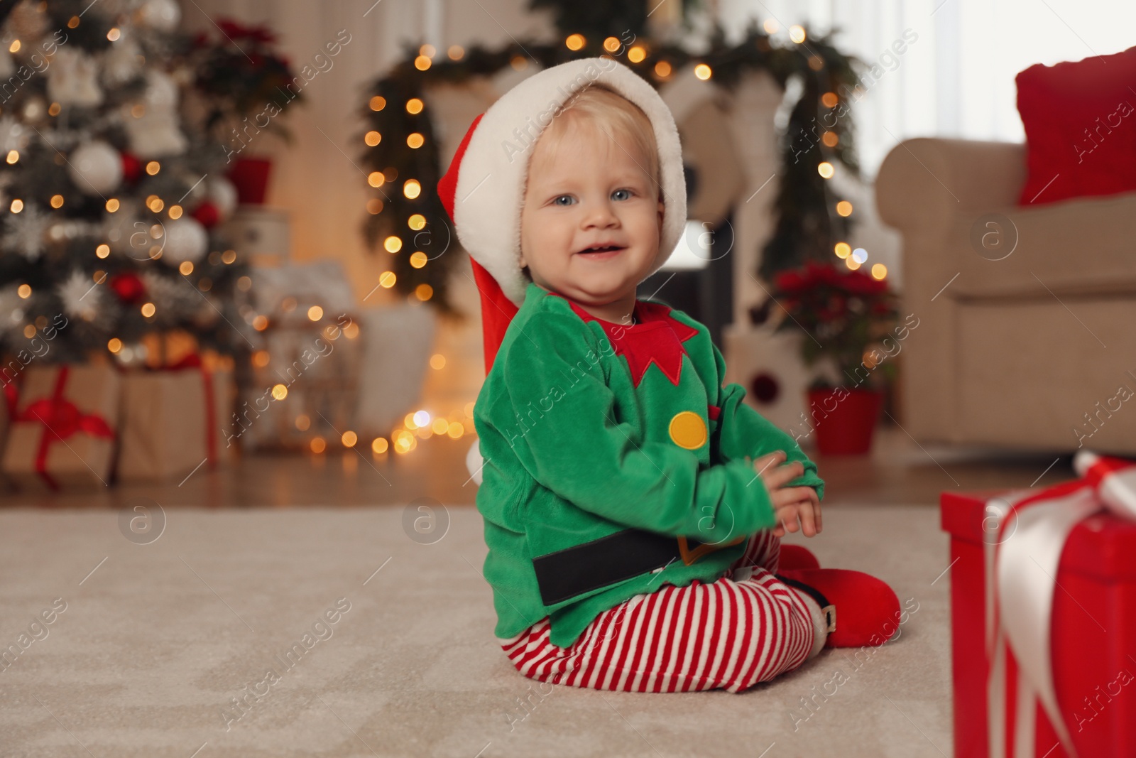 Photo of Cute baby in Santa's elf clothes at home. Christmas suit